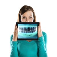 Woman holding tablet with dental x-ray